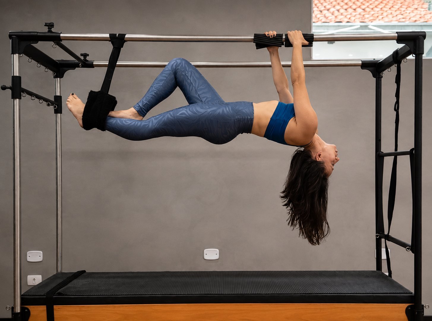 Aluna realizando exercício de Pilates no aparelho Cadillac, com acompanhamento individual no Studio Daiana Duarte